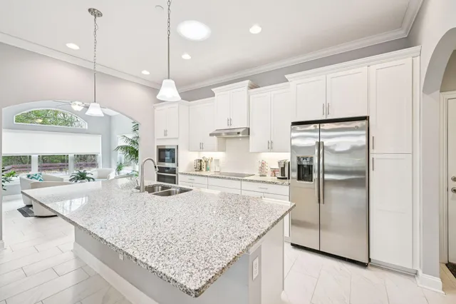 a kitchen with stainless steel appliances granite countertop a refrigerator a sink and a refrigerator