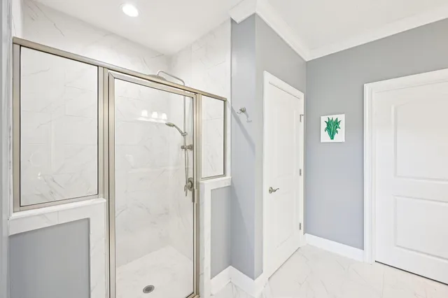 a bathroom with a glass shower door and a glass door