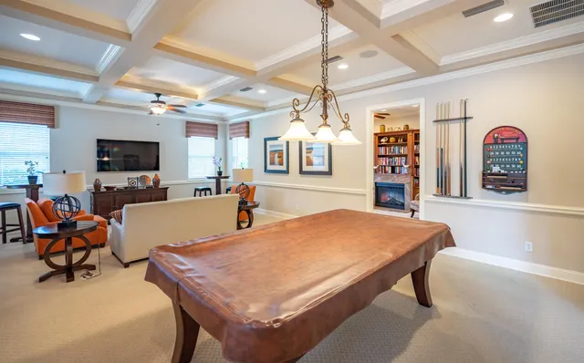 a living room with furniture a flat screen tv and kitchen view