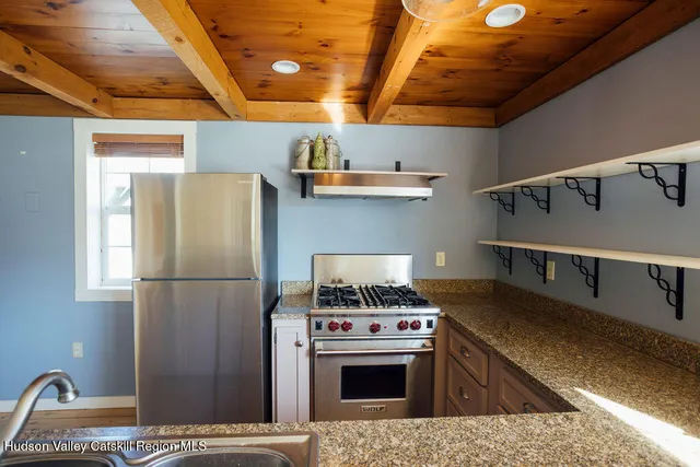 a kitchen with stainless steel appliances granite countertop a refrigerator a stove and a sink