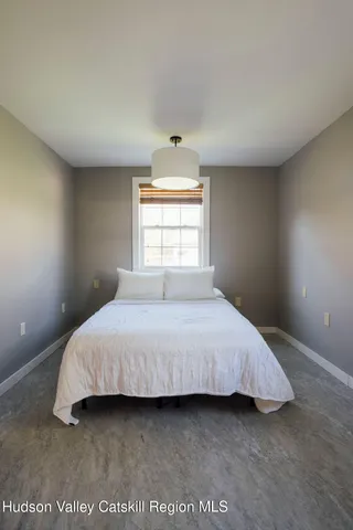 a bedroom with a bed and window