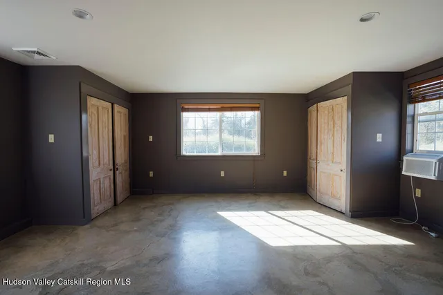 an empty room with windows and closet