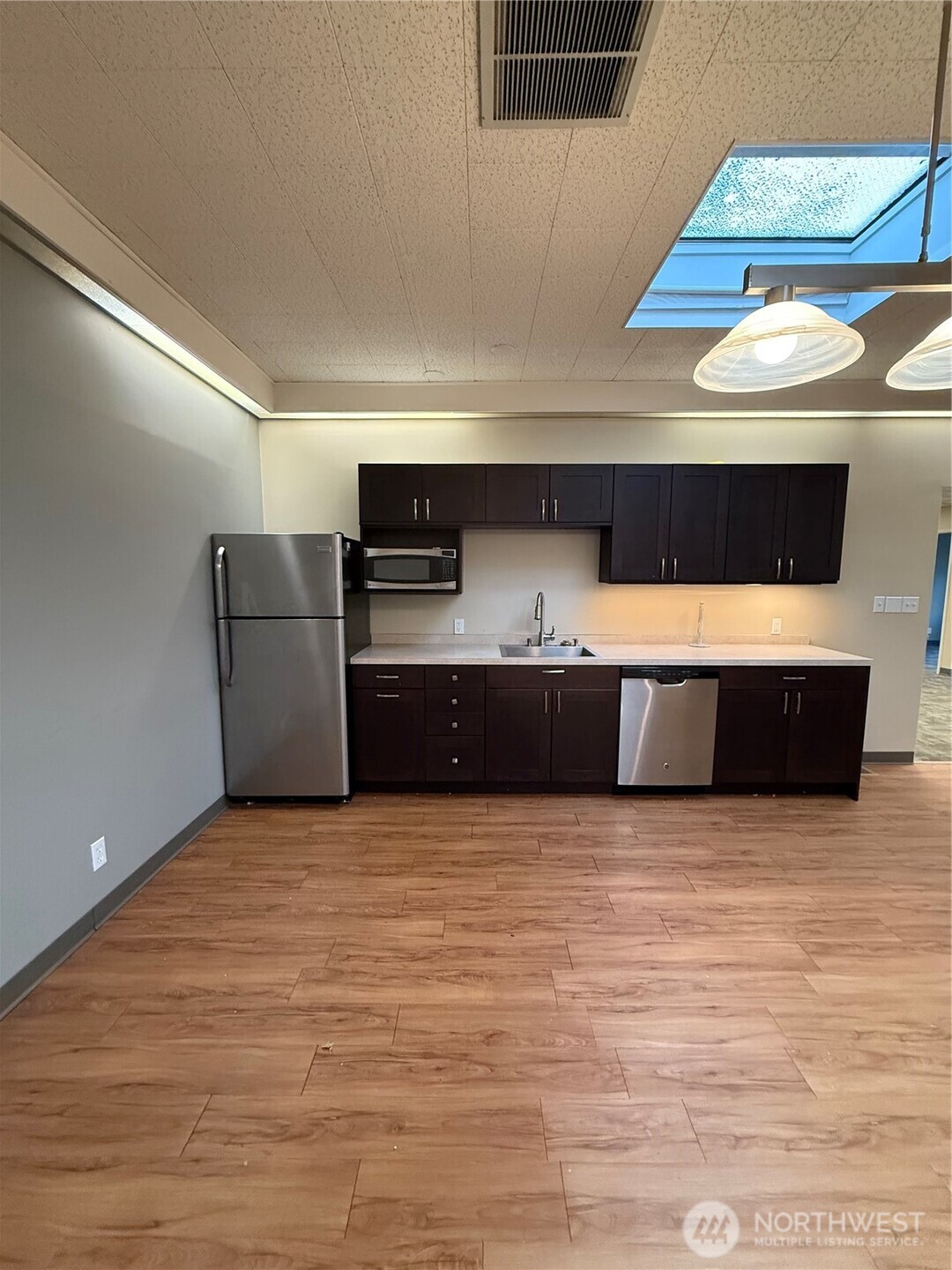 111 West Harrison Street Seattle, WA 98119 - Photo 9 of 25 a kitchen with stainless steel appliances a cabinets and a fireplace