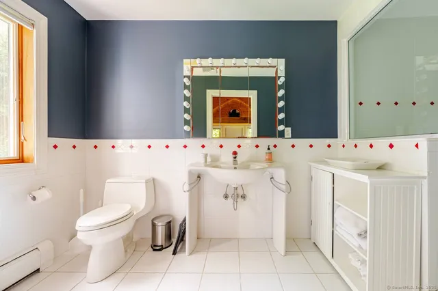 a bathroom with a sink a toilet and a mirror