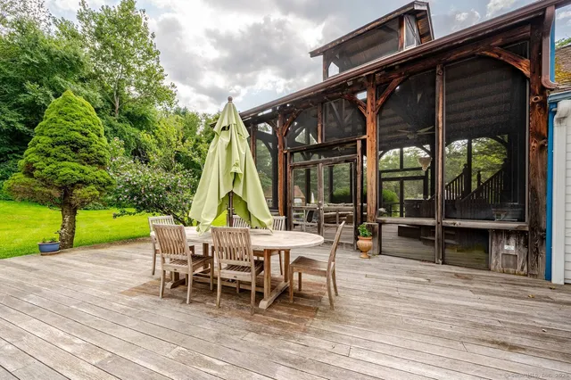 a view of a house with wooden deck and furniture