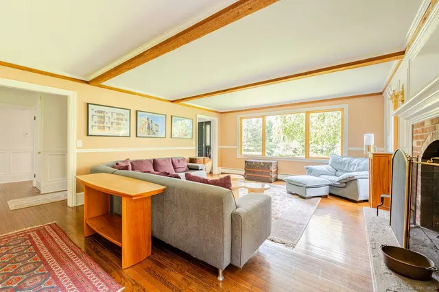 a living room with fireplace furniture and a large window