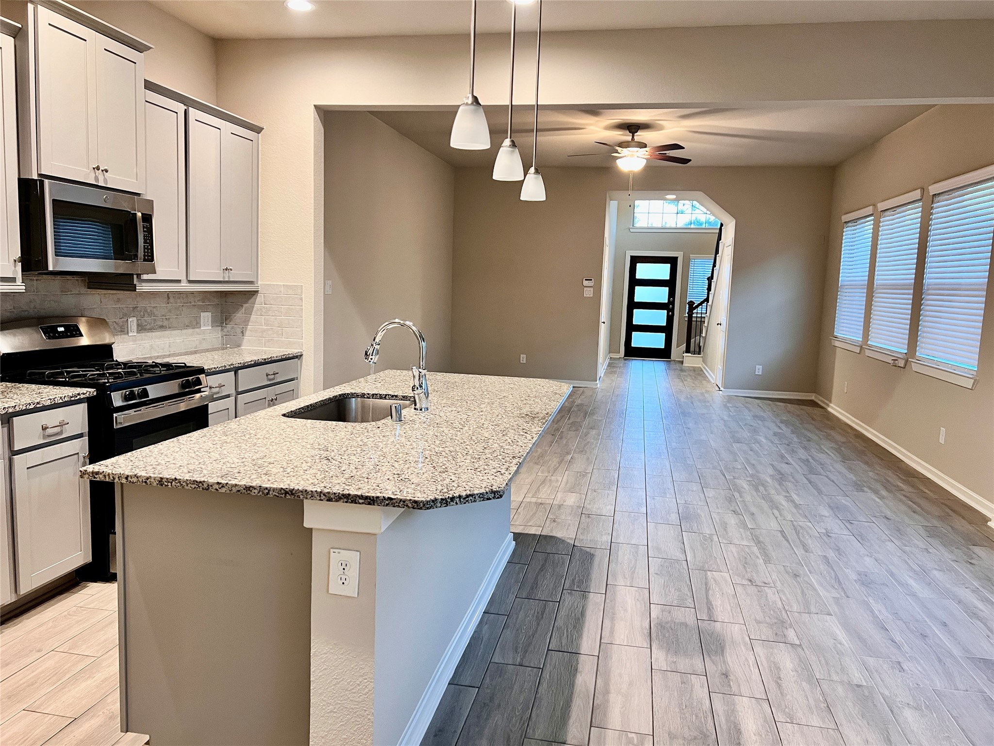 7912 Spring Run North Richland Hills, TX 76182 - Photo 14 of 21 a kitchen with granite countertop a stove top oven a sink dishwasher and a microwave with wooden floor