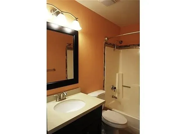 a bathroom with a sink toilet a mirror and shower