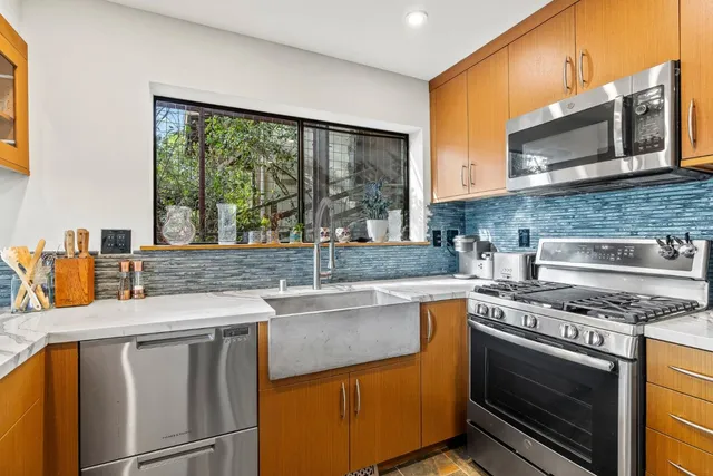 a kitchen with stainless steel appliances granite countertop a sink stove and microwave