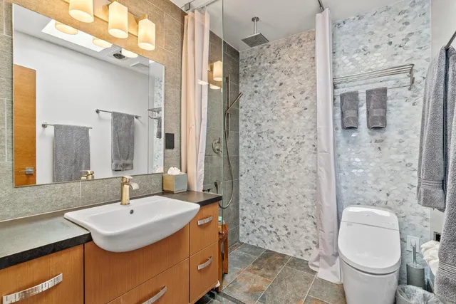 a bathroom with a sink toilet a shower and a mirror