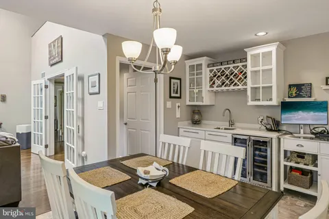 a kitchen with a dining table chairs refrigerator and microwave