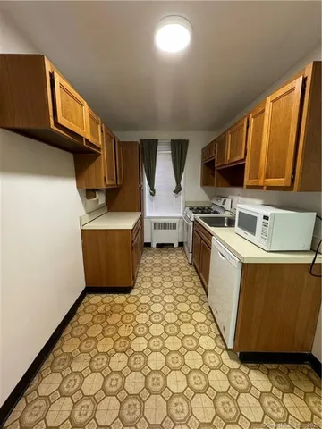 a kitchen with a sink a stove top oven a chimney and a refrigerator