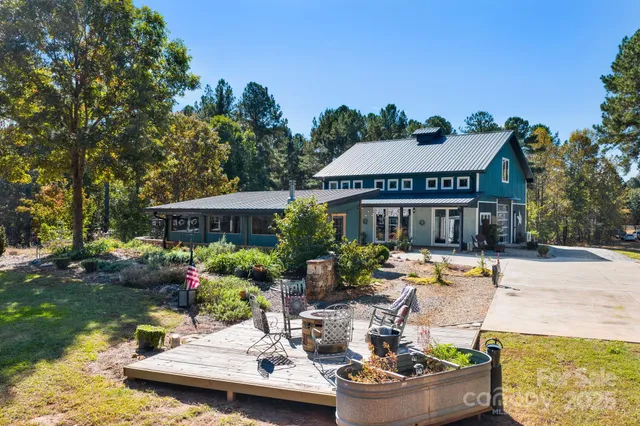 a view of a house with backyard water fountain and sitting area