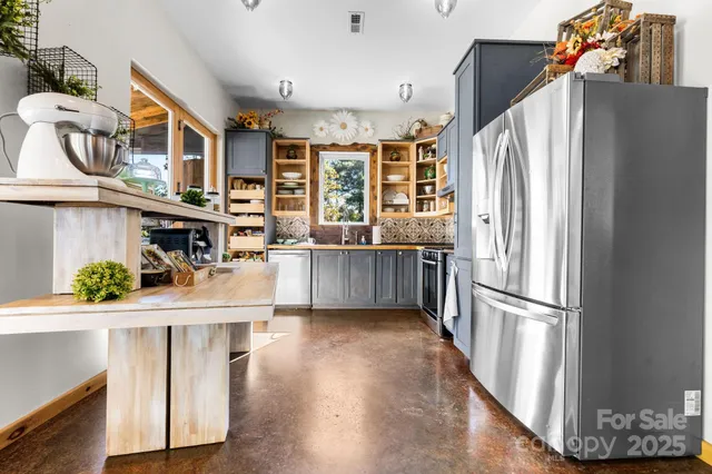 a kitchen with stainless steel appliances granite countertop a refrigerator and a stove