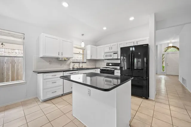 a kitchen with stainless steel appliances granite countertop a sink and cabinets