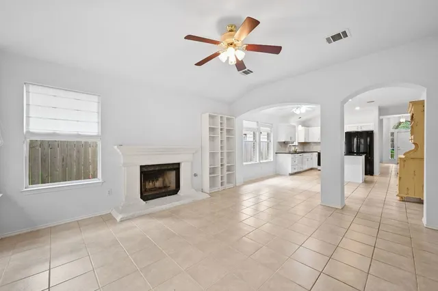 a view of an empty room with a fireplace and a window