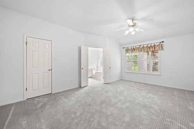 a view of a livingroom with a kitchen counter tops and a ceiling fan
