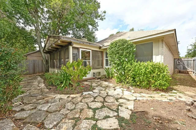 a backyard of a house with plants and trees
