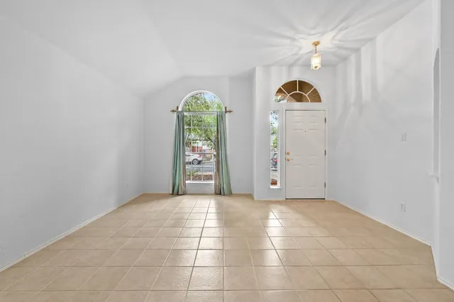 an empty room with windows and ceiling fan