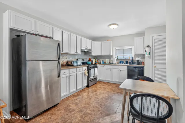 a kitchen with stainless steel appliances granite countertop a refrigerator a stove a sink and a refrigerator