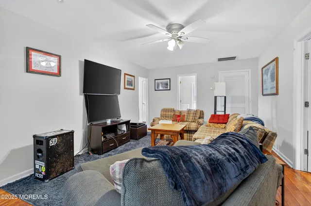 a kitchen with stainless steel appliances granite countertop a stove a refrigerator a sink a stove and white cabinets with wooden floor