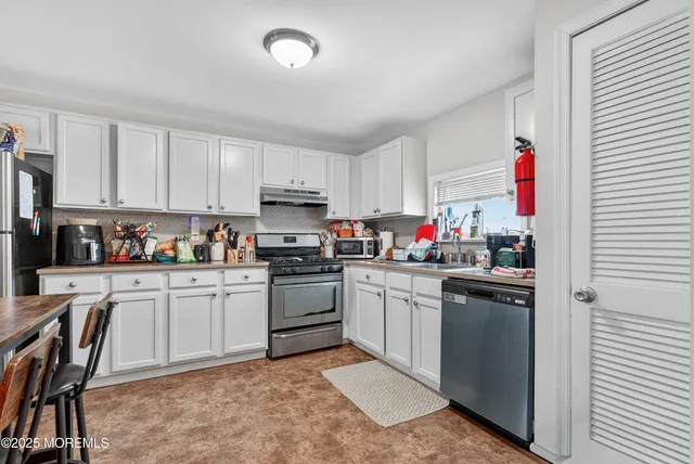 a kitchen with a refrigerator a table and chairs in it