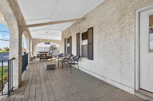 a view of a patio with dining table and chairs with wooden floor and fence