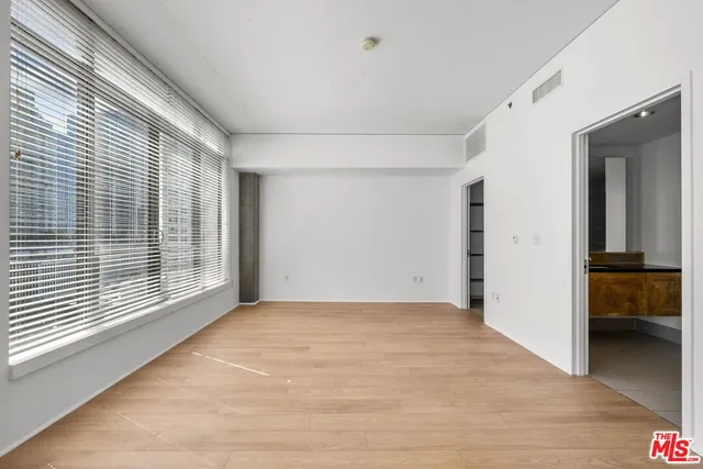 a view of an empty room with closet and a window