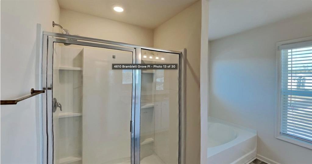 4610 Bramblett Grove Place Cumming, GA 30040 - Photo 14 of 20 a bathroom with a glass shower door