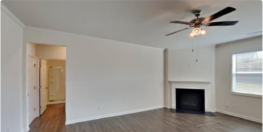 4610 Bramblett Grove Place Cumming, GA 30040 - Photo 2 of 20 a view of a livingroom with a fireplace a ceiling fan and wooden floor