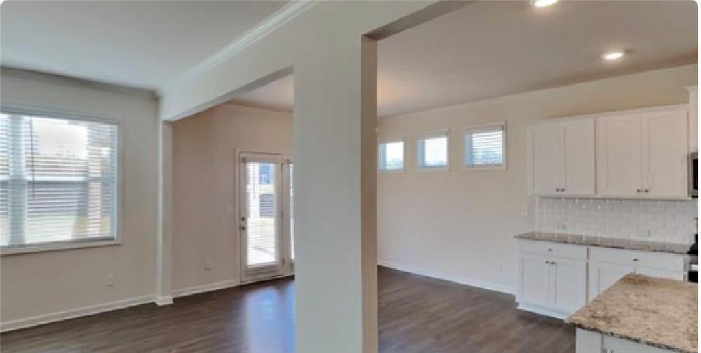4610 Bramblett Grove Place Cumming, GA 30040 - Photo 4 of 20 a view of an empty room with wooden floor and a window