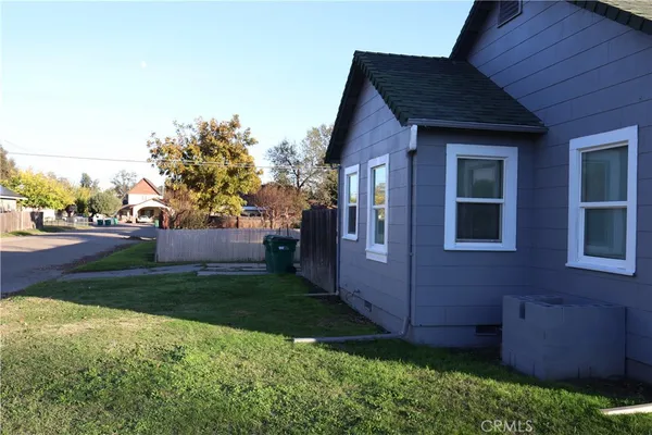 a view of backyard of house with wooden fence