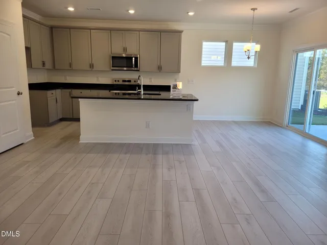 a kitchen with granite countertop a sink stove and cabinets