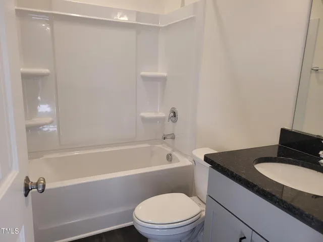 a white toilet sitting next to a bath tub