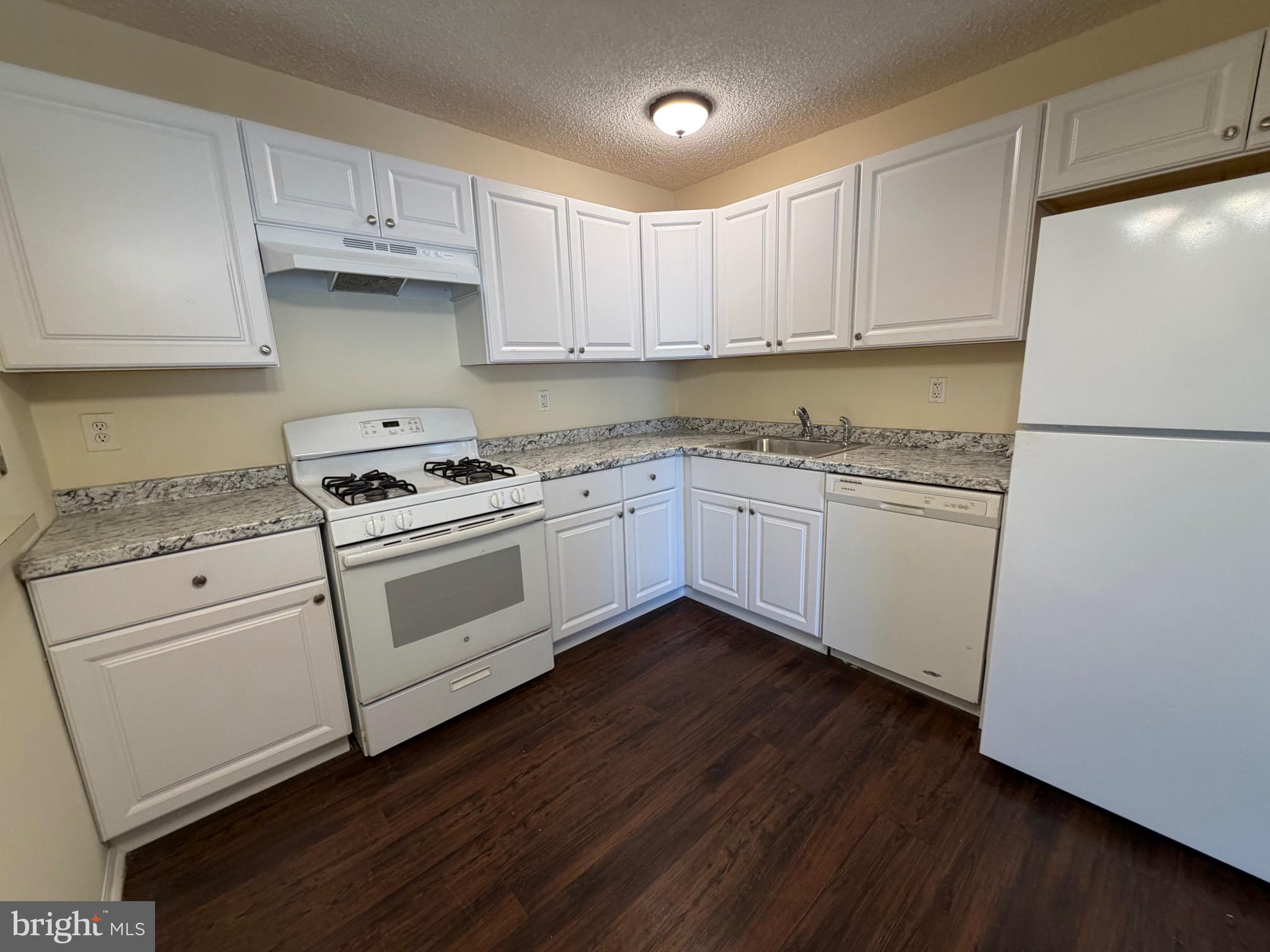64 Mattix Run Absecon, NJ 08205 - Photo 4 of 14 a kitchen with granite countertop white cabinets and white appliances