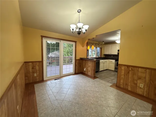 a large kitchen with a sink and chandelier
