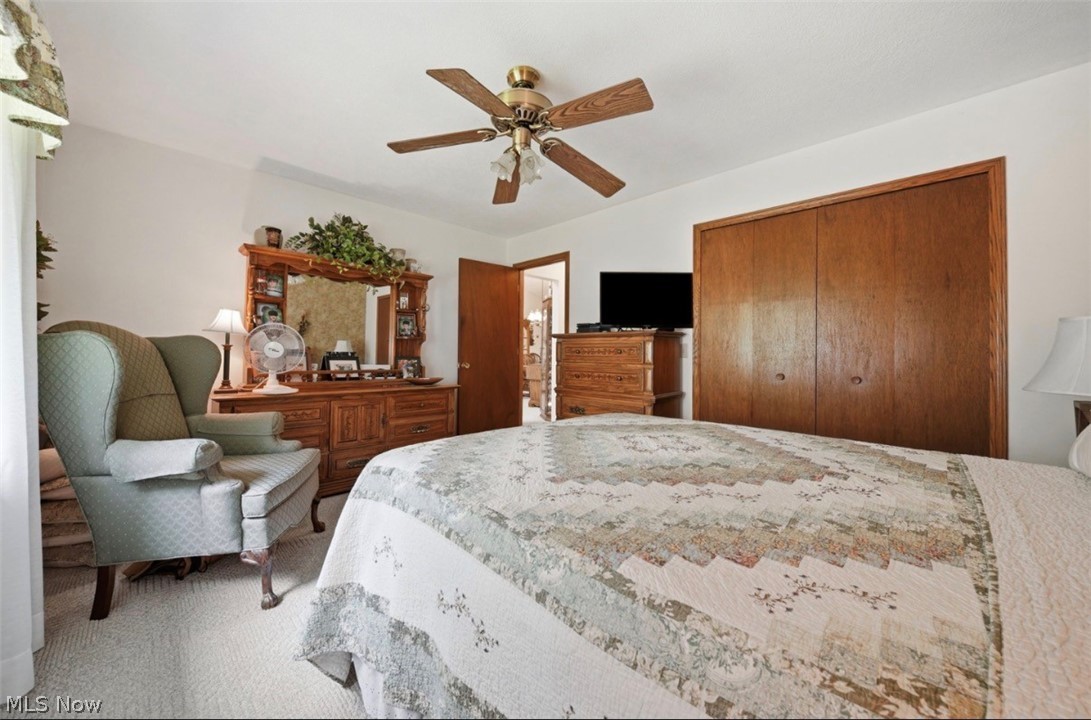 3556 Lake Road Conneaut, OH 44030 - Photo 31 of 39 Carpeted bedroom with a ceiling fan, wood-finish bi-fold closet doors, and white walls