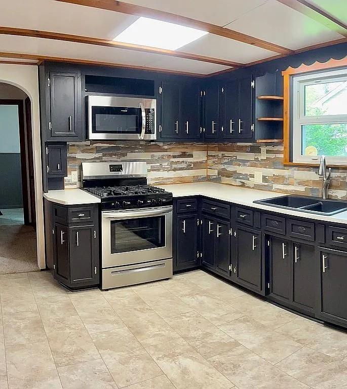 449 Race Street Waynesburg, PA 15370 - Photo 7 of 20 a kitchen with stainless steel appliances granite countertop a stove a sink and a microwave