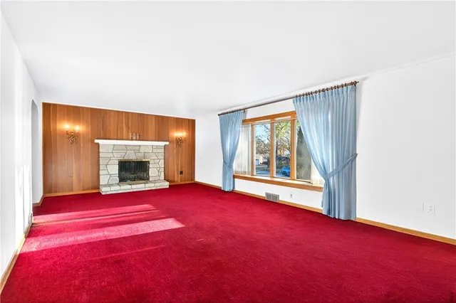 a view of an empty room with a fireplace and a large window