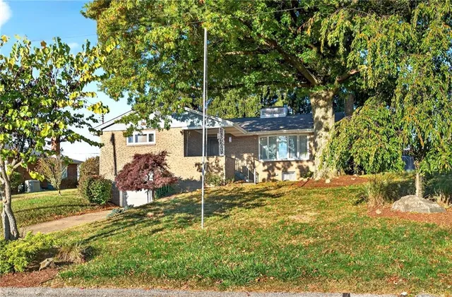 a view of a house with backyard and sitting area