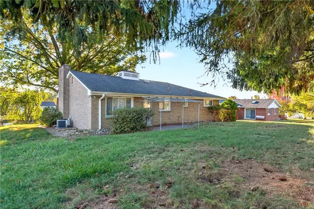 a view of a yard in front of a house with large trees