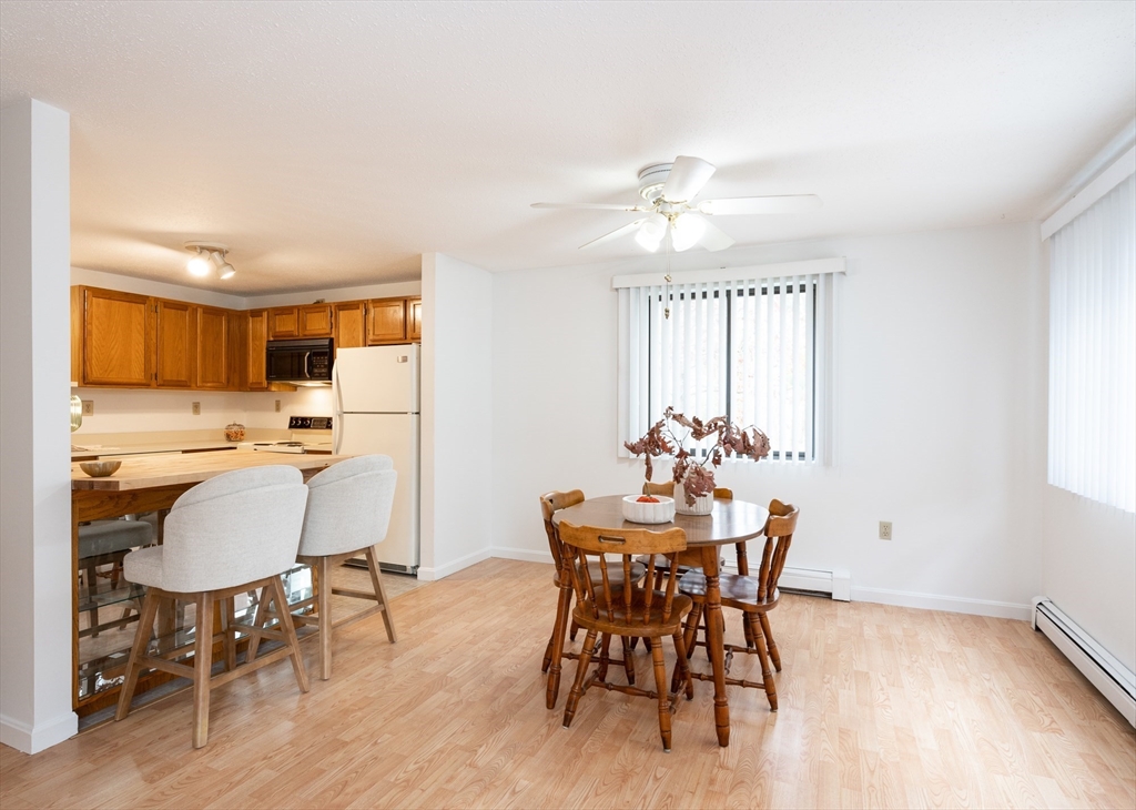 98 Indian Rock Road, Unit 98 Merrimack, NH 03054 - Photo 12 of 40 a view of a dining room with furniture window and wooden floor
