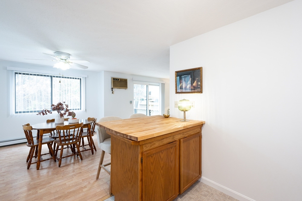 98 Indian Rock Road, Unit 98 Merrimack, NH 03054 - Photo 15 of 40 a dining room with a wooden table and chairs
