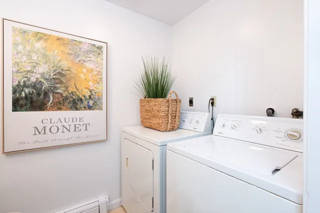 a view of washer and dryer with bathroom in the background