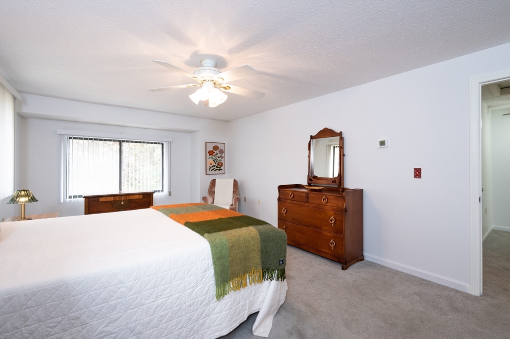 98 Indian Rock Road, Unit 98 Merrimack, NH 03054 - Photo 19 of 40 a bedroom with a bed and a chandelier