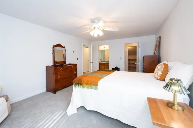 a spacious bedroom with a bed and a chandelier