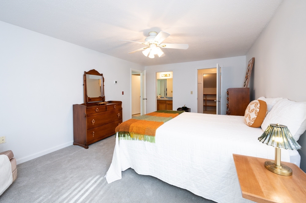 98 Indian Rock Road, Unit 98 Merrimack, NH 03054 - Photo 21 of 40 a spacious bedroom with a bed and a chandelier