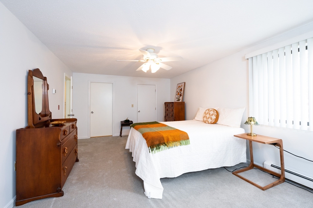 98 Indian Rock Road, Unit 98 Merrimack, NH 03054 - Photo 22 of 40 a bedroom with a bed and flat tv screen on the dresser