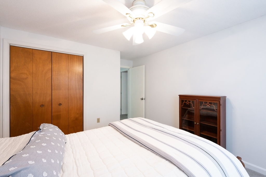 98 Indian Rock Road, Unit 98 Merrimack, NH 03054 - Photo 27 of 40 a bedroom with a bed and a dresser