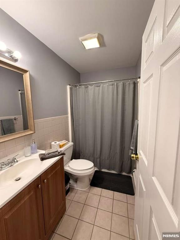 168 Grove Street Passaic, NJ 07055 - Photo 12 of 12 a bathroom with a sink a toilet a mirror a vanity and shower